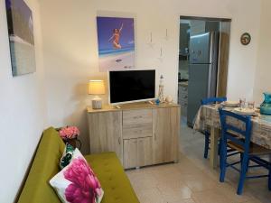un soggiorno con TV e tavolo da pranzo di Villa Antonietta By Cala Salento a Punta Prosciutto