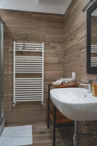 een badkamer met een witte wastafel en houten wanden bij Ulivo Design b&b in Reggio di Calabria