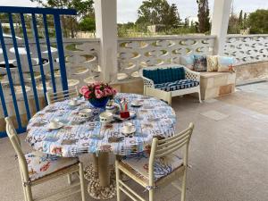 un tavolo con una ciotola di fiori su un patio di Villa Antonietta By Cala Salento a Punta Prosciutto