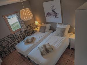 a bedroom with two beds with pillows and a window at The Hunting Lodge in Landry