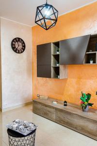 a living room with a counter and a clock at Peter's House 2 in Calatabiano