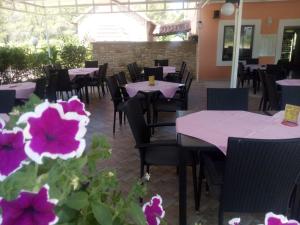 een restaurant met paarse tafels, stoelen en bloemen bij Pansion restoran Marin in Posedarje +15 foto's