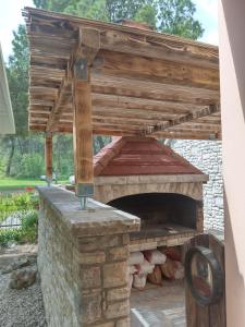 een pizzaoven in de openlucht met een houten dak bij Pansion restoran Marin in Posedarje
