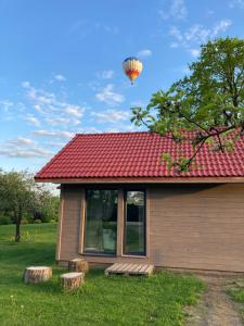 a hot air balloon flying over a house at Holiday house Ausekļa namiņš in Cēsis