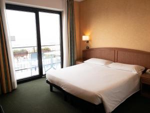 a hotel room with a bed and a large window at Hotel Santa Maria in Chiavari