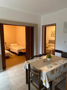 Zimmer mit 2 Betten, einem Tisch und einem Spiegel in der Unterkunft Apartment Mare Krk in Milohnići