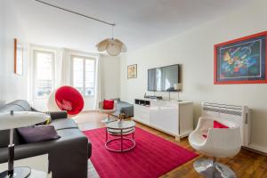 a living room with a couch and a red rug at Saint Honore Louvre in Paris