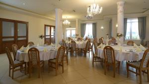 a large dining room with white tables and chairs at Magnat w Borczu in Borcz
