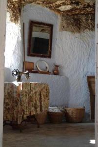 baño con lavabo, espejo y cestas en Hábitat Troglodita Almagruz, en Purullena 37 fotos más