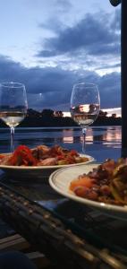 due piatti di cibo e due bicchieri di vino su un tavolo di Top Chill splav kucica a Belgrado