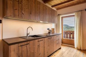 a kitchen with a sink and a large window at Ferienwohnung Aster Nusserhof in Avelengo