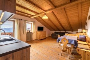 cocina y sala de estar con mesa y fregadero en Ferienwohnung Aster Nusserhof, en Avelengo