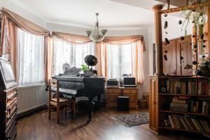 a living room with a piano and a desk at Imádó Vendégház in Cernatu de Sus