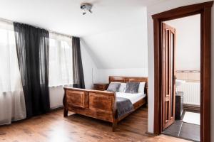 a bedroom with a wooden bed and a mirror at Imádó Vendégház in Cernatu de Sus