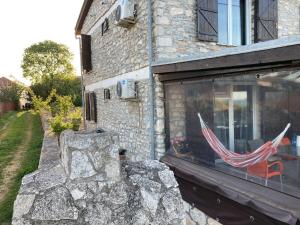 una casa de piedra con una ventana con una bandera. en Prison de la Mer, en 2 Mai