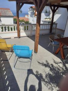 une ombre d'une personne debout sur une terrasse avec des chaises dans l'établissement Apartments Balen, à Rab