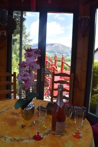 una mesa con dos copas de vino y una botella en ella en Gîte Au printemps Japonais, petit train de la Mure, parc des Ecrins, en Pierre-Châtel