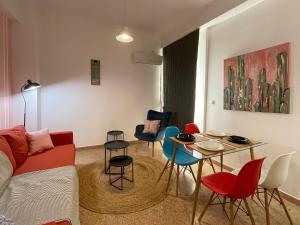 a living room with a couch and a table and chairs at SOHO Vibrant 55sqm apt in Athens in Athens