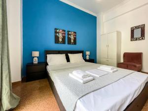 a blue bedroom with a bed with towels on it at SOHO Vibrant 55sqm apt in Athens in Athens