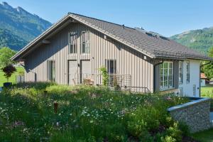 a house with a garden in front of it at Ferienwohnungen am Lochbach in Aschau im Chiemgau