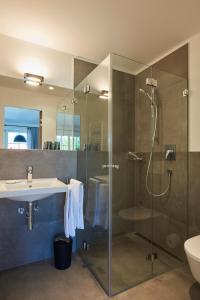 a bathroom with a glass shower and a sink at Ferienwohnungen am Lochbach in Aschau im Chiemgau +24 photos