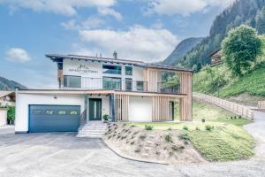 a house with a garage and a mountain at Apart Gstrein - Ski-In & Ski-Out in See