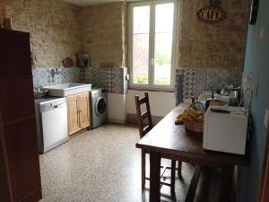 cocina con mesa, fregadero y lavadora en Superbe logement dans une maison de caractère en Toul