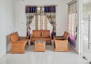 a room with chairs and a table and a window at RedDoorz Syariah near Sunrise Park Pangandaran in Pangandaran