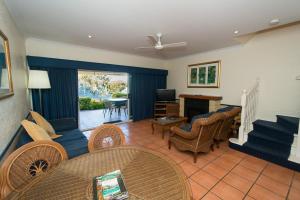 a living room with a couch and chairs and a television at Tinaroo Lake Resort in Tinaroo