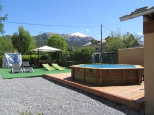 una piscina en un patio con 2 sillas y una mesa en Chambre d'Hotes La Mexicaine en Jausiers