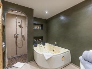 ein Badezimmer mit einer großen Badewanne und einer Dusche in der Unterkunft Appartement Bergblick in Ellmau