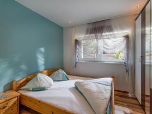 1 dormitorio con cama de madera y ventana en Appartement Bergblick, en Ellmau