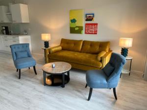 uma sala de estar com um sofá e duas cadeiras e uma mesa em Das Hotel Ostseeblick em Lütjenburg