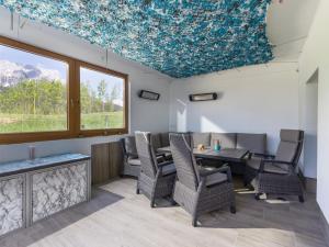 ein Esszimmer mit Tisch und Stühlen und Fenstern in der Unterkunft Appartement Bergblick in Ellmau