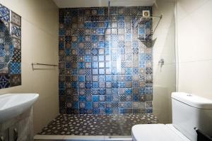 a bathroom with a shower with blue and gray tiles at Ocean blues Isikhulu 7 in Umdloti +19 photos