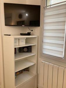 a living room with a tv on a wall at Appartement Les Amethystes 1 in Le Mont-Dore