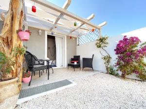 a patio with a table and chairs and flowers at La Cuppulata 2 - Stile Mare in Enas