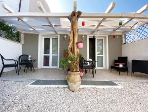a patio with a wooden ceiling and a tree at La Cuppulata 2 - Stile Mare in Enas