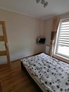 1 dormitorio con cama y ventana en Apartament SunSet, en Gdynia
