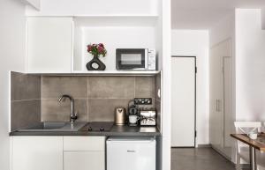 eine Küche mit einer Spüle und einer Mikrowelle in der Unterkunft The Square Six in Athen