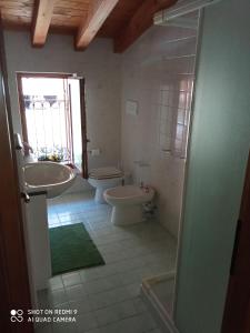 uma casa de banho com um lavatório, uma banheira e um WC. em B&B In Contrá em Selva di Progno