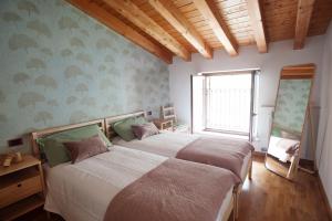 1 dormitorio con 2 camas y ventana en B&B In Contrá en Selva di Progno