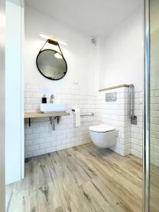 W łazience znajduje się umywalka, toaleta i lustro. w obiekcie Domki Nord Star we Władysławowie