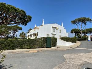 una casa blanca con una puerta frente a una calle en Praia da Falésia Alfa Mar Albufeira, en Olhos de Água