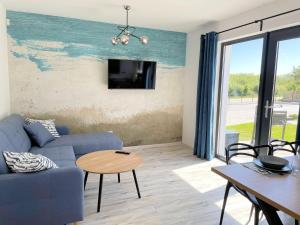 a living room with a blue couch and a tv at Domki Nord Star in Władysławowo