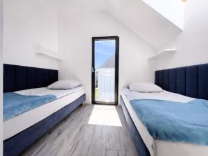 dwa łóżka w pokoju z oknem w obiekcie Domki Nord Star we Władysławowie