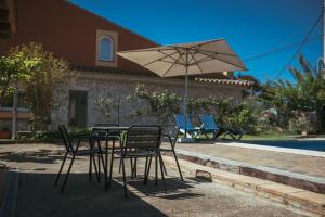 een tafel en stoelen met een parasol voor een huis bij Casa Adela in Begur