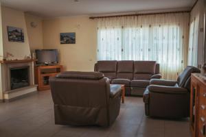 Una sala de estar con sofás y un televisor. en Casa Adela, en Begur