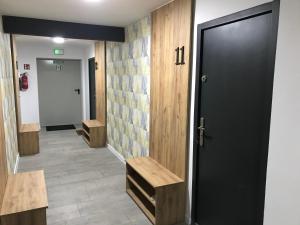 a hallway with a black door and wooden walls at Apart - apartament 12 in Okuninka +3 photos