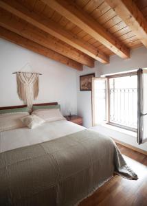 a bedroom with a large bed and a large window at B&B In Contrá in Selva di Progno